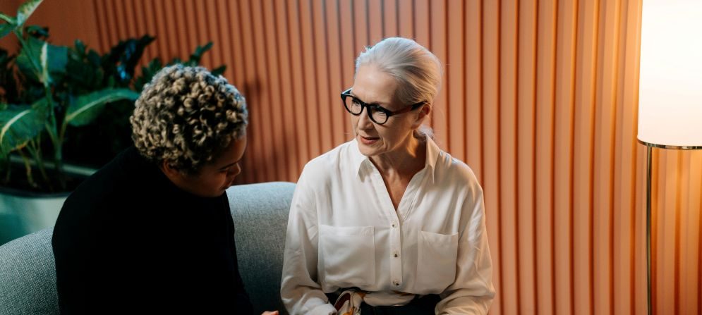 2 Women sitting on a sofa having a discussions
